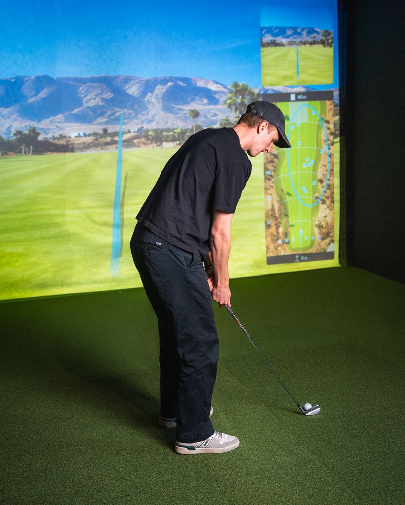 A player lining up a putt on a Trackman simulator